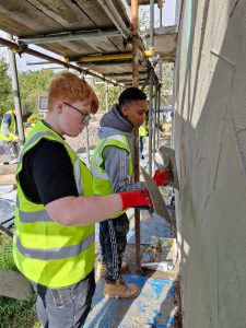 Two people plastering on a construction site