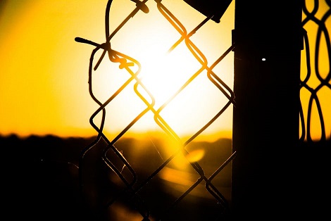 Image of sun setting see through a wire fence