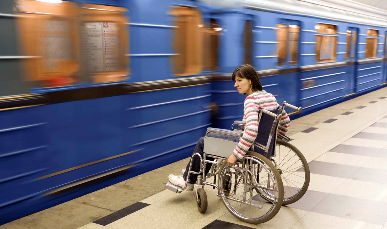 Woman in wheelchair waiting for a train