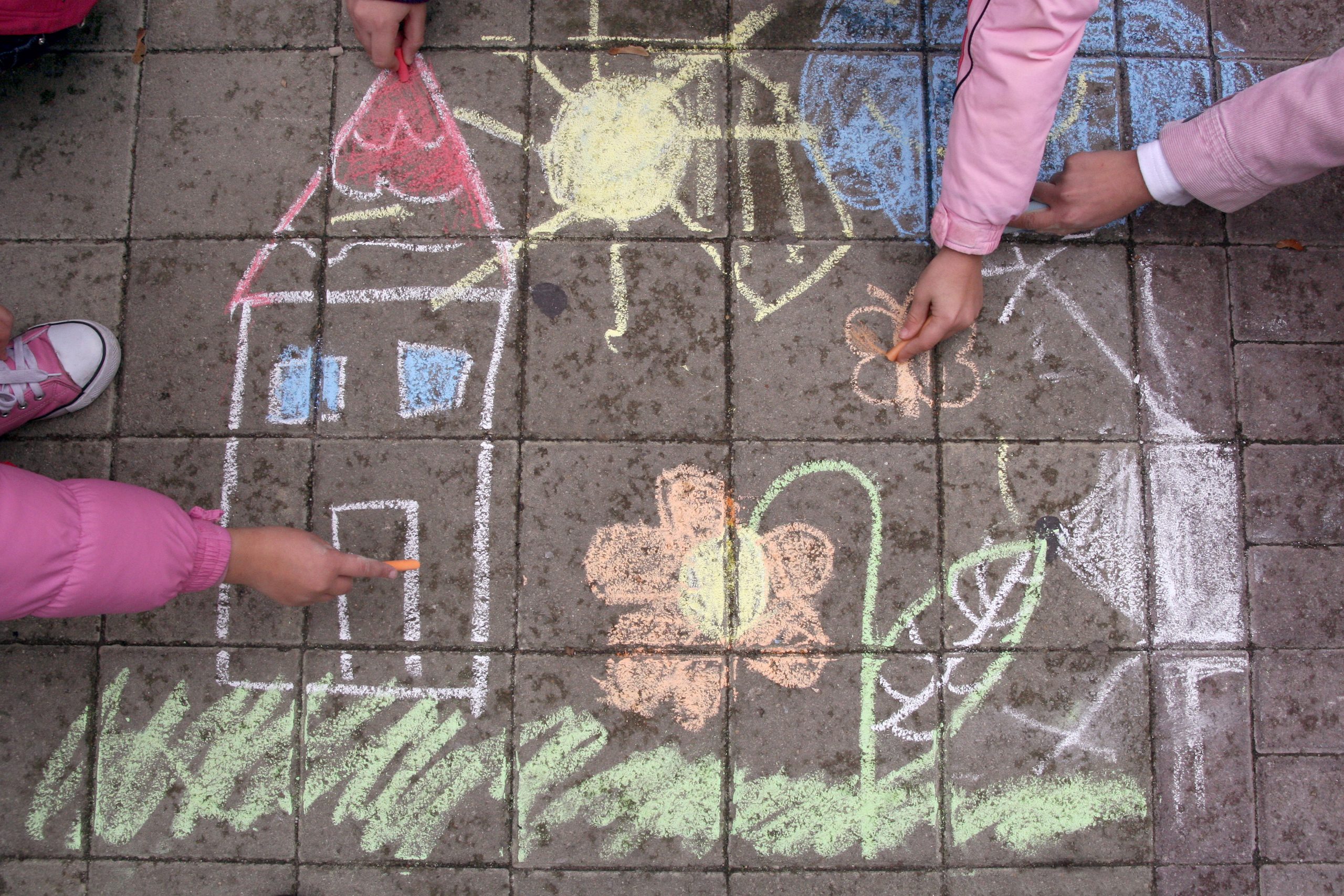 A house in chalk being drawn by children
