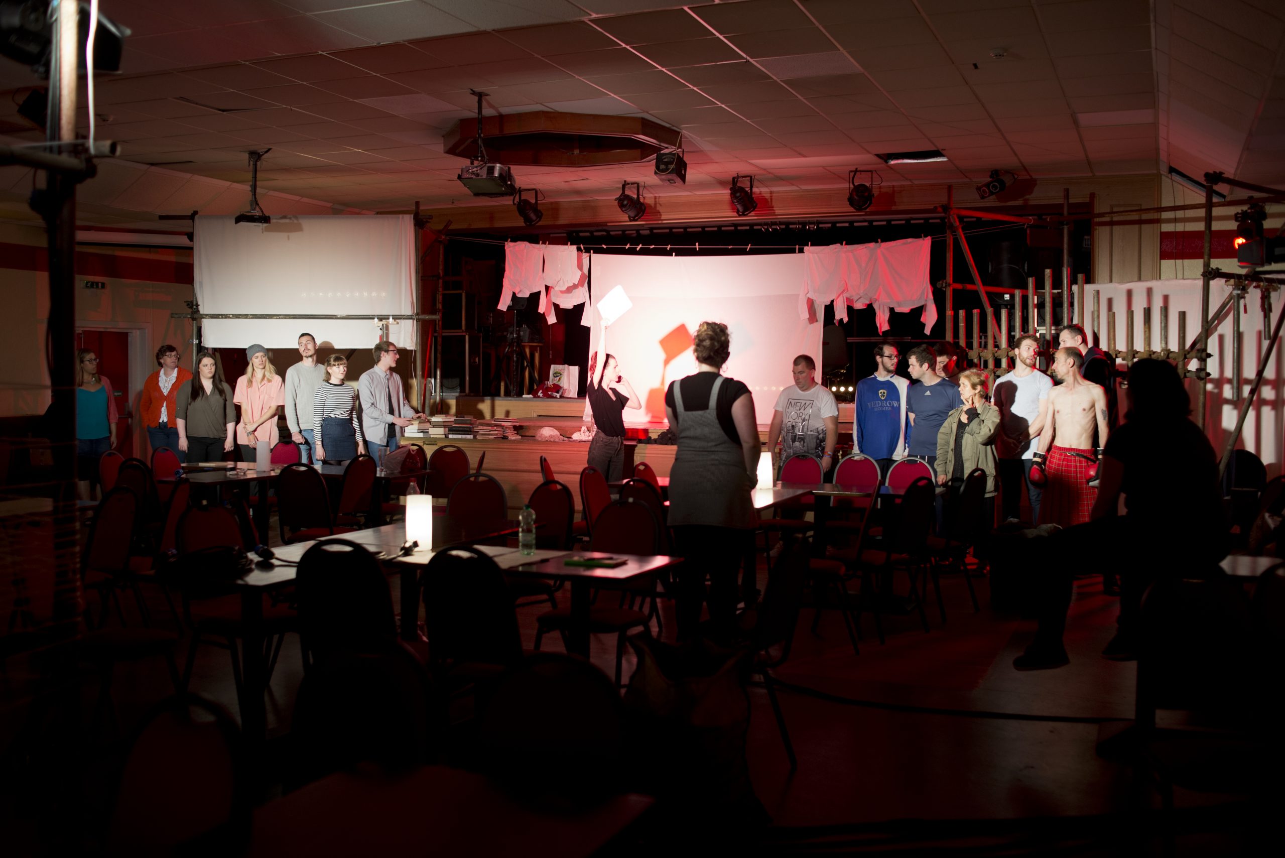 A group of standing actors in a room