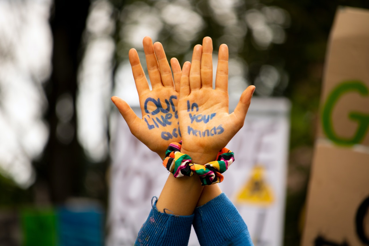 Child's hands with the words 'our lives are on your hands' written on