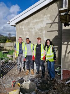 Group shot of young people on a construction site wearing high-vis jackets