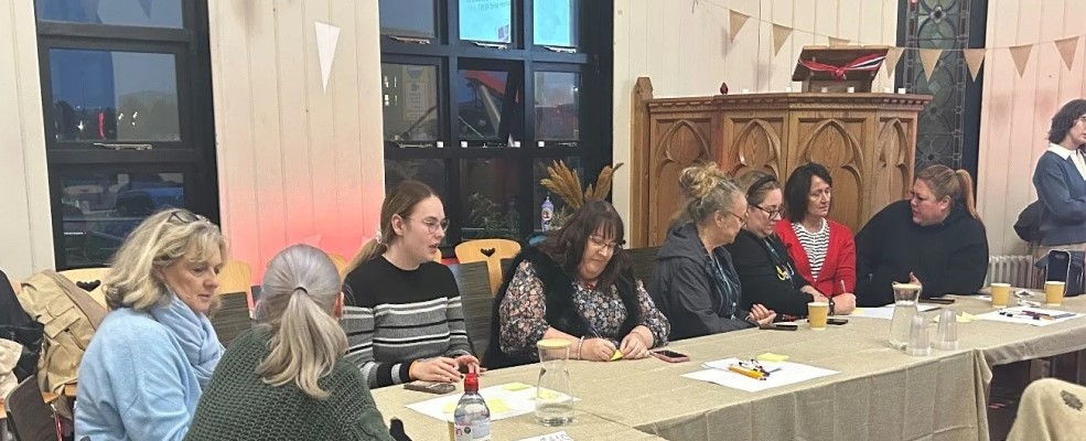 Workshop participants sitting round a table in the Norwegian Church in Cardiff Bay.