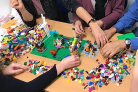 Adults using Lego to build a diving board