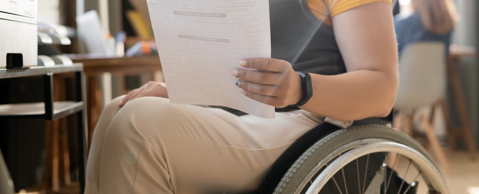 Person in wheelchair looking at piece of paper