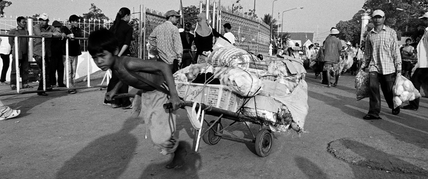 Picture of child labourer in Cambodia, young boy pulling heavy cart.