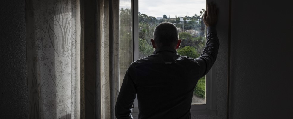 View from behind man looking out of window.