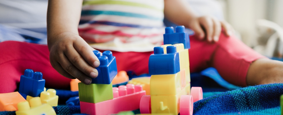 Child playing with colourful building blocks